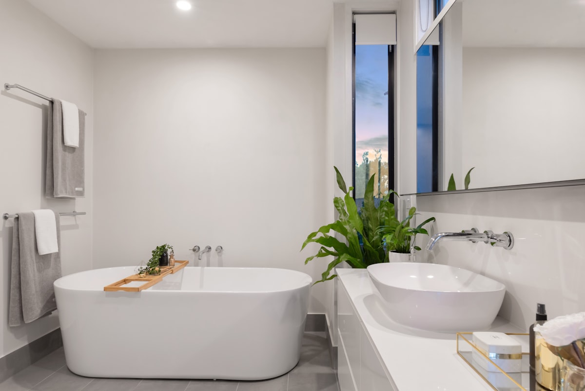 A simple bathroom with a low-threshold shower and a plain white finish.