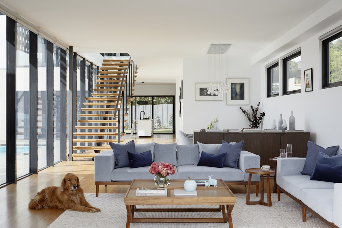 A calm living space in soft neutral tones with dimmable lamps and no patterned surfaces.