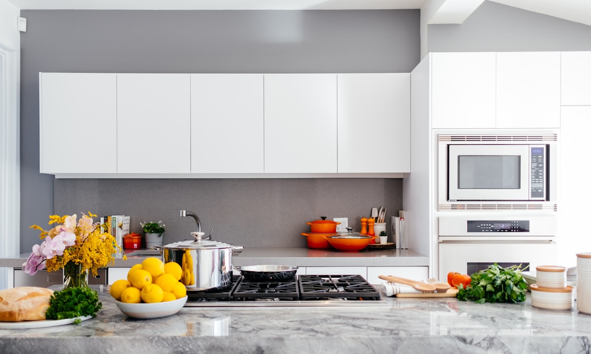 A kitchen with one lowered worktop section and an induction hob with a removable guard.